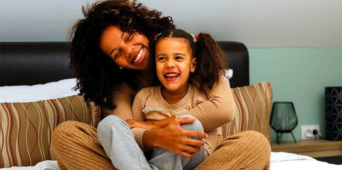 mother cuddling with young daughter