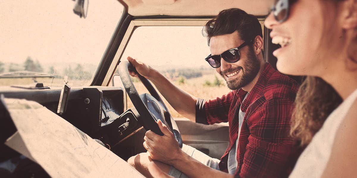 man and woman driving with a map