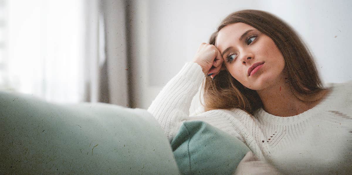 woman thinking of something sitting on couch