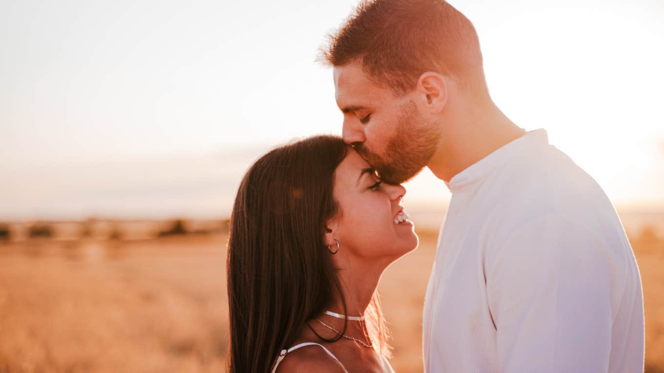 Man kisses girlfriend on forehead 