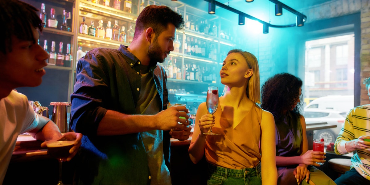 man and woman flirting at bar
