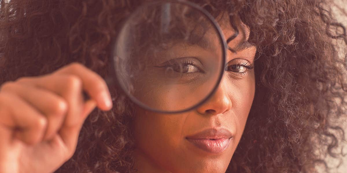 woman holding magnifying glass