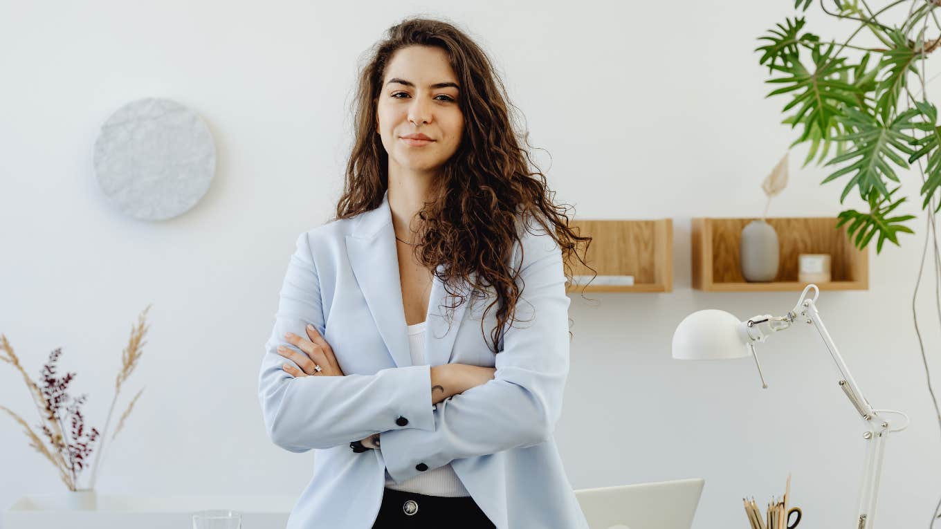 woman in a blazer standing at desk 