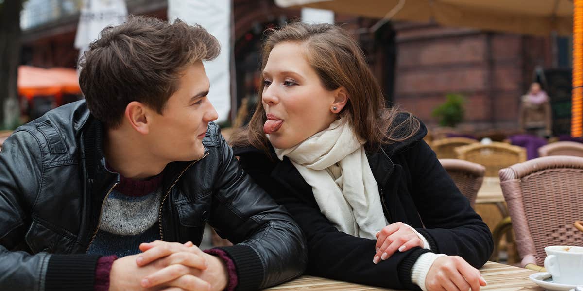 woman sticking tongue out at man