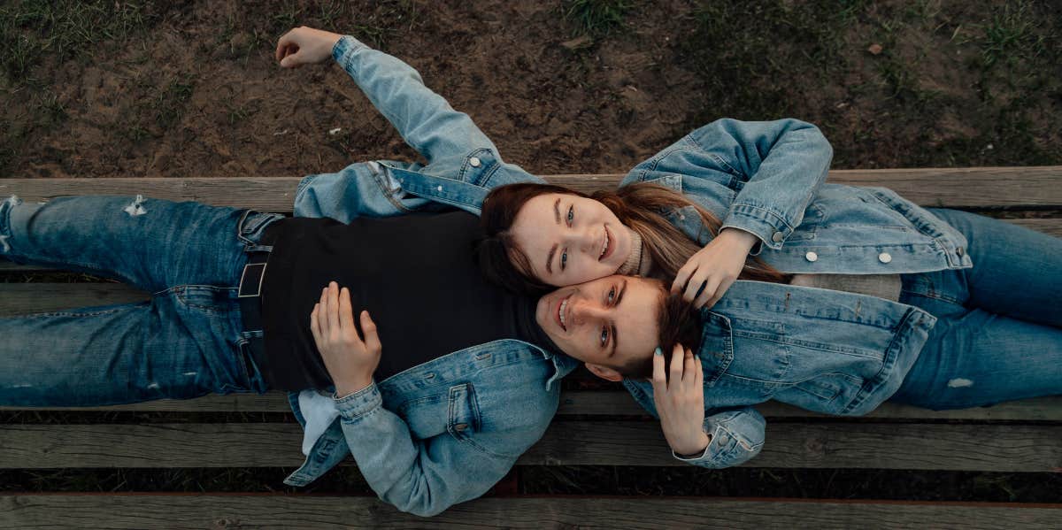 couple laying on bench