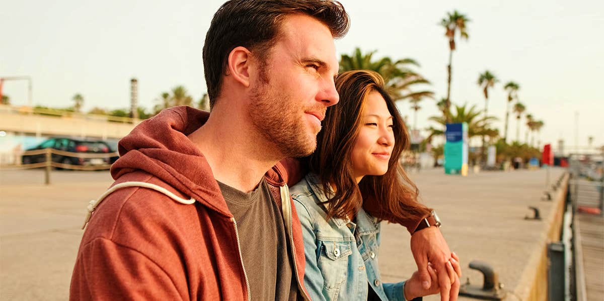 man and woman sitting outside on pier