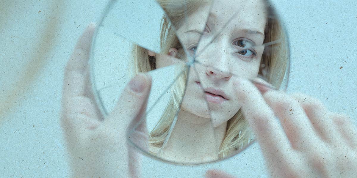 A woman looking into a broken glass