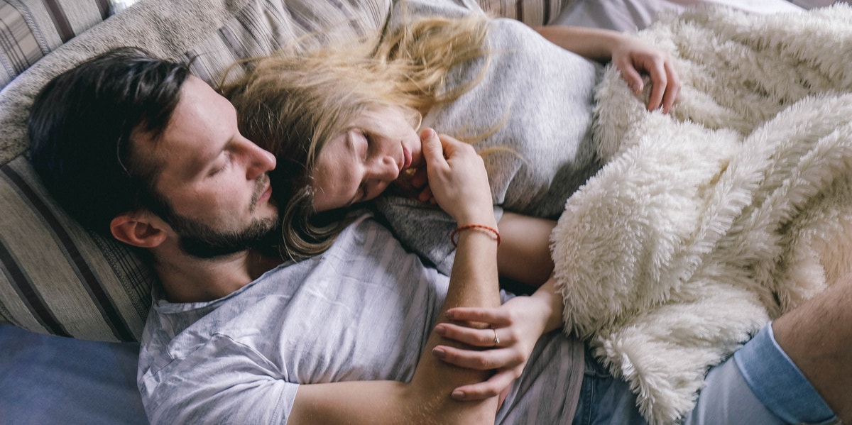 woman and man cuddling in bed