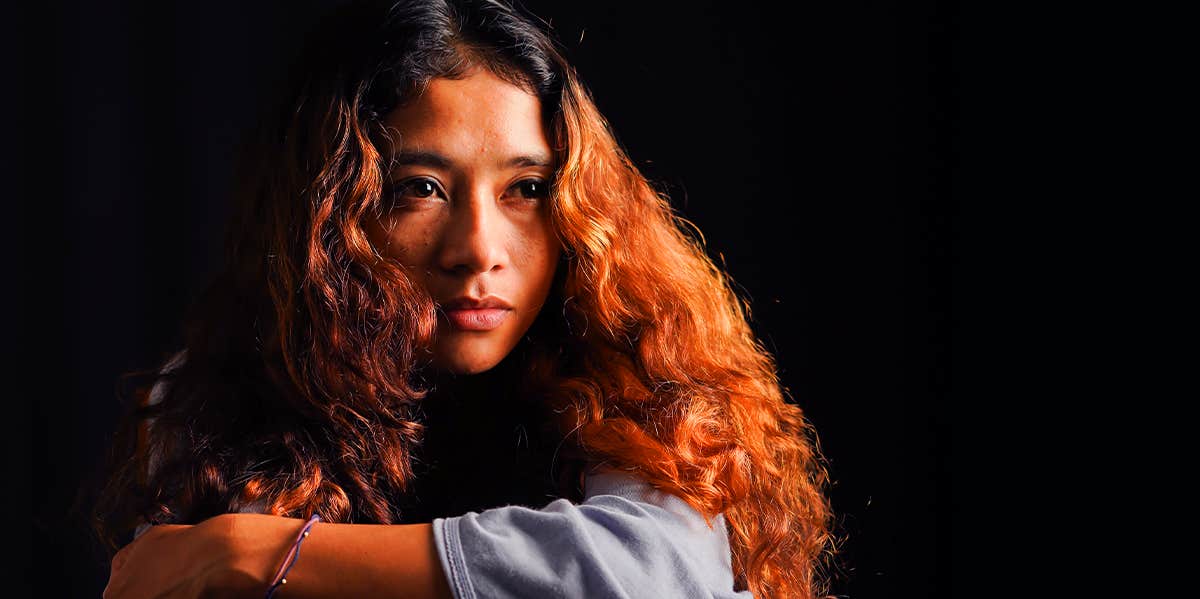 7 Reasons People Would Rather Be in An Unhealthy Relationship woman sitting in the dark