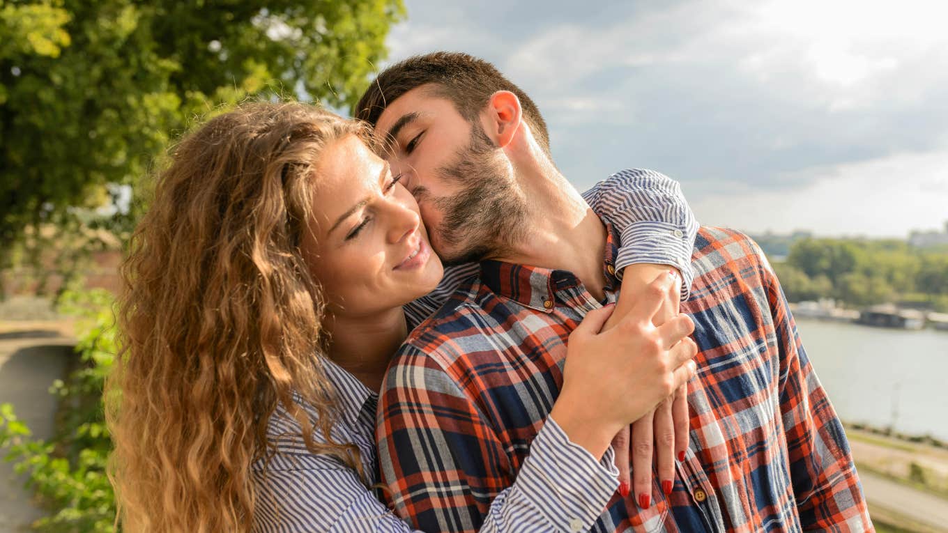Man kissing his woman on the cheek 