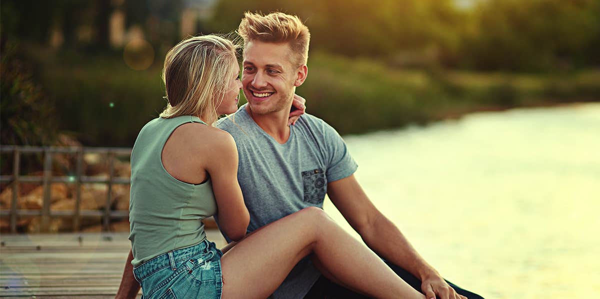 man and woman cuddling by lake