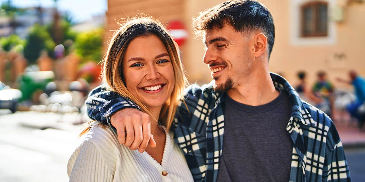 man with arm around girlfriend