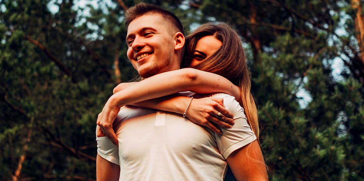 smiling couple with woman on man's back