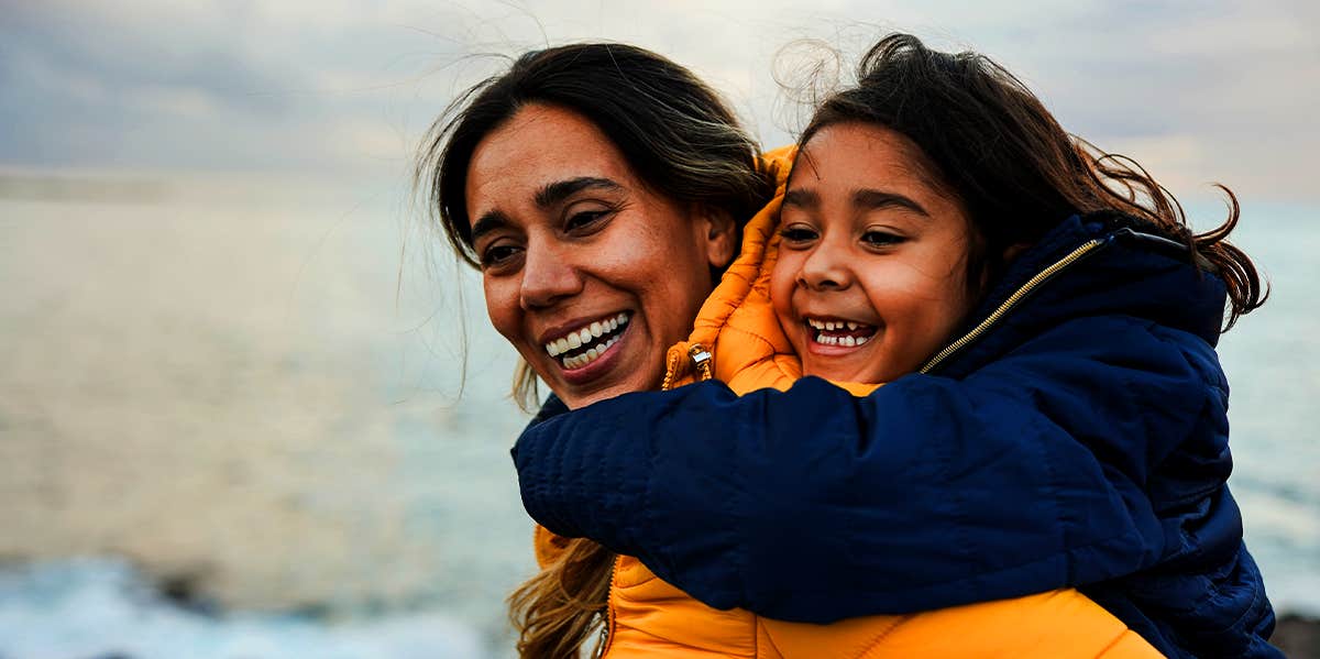 mother carrying daughter on back