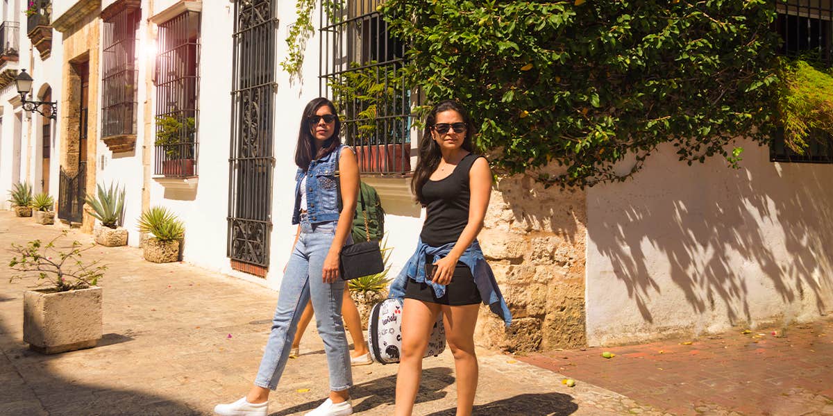 two women on the street with luggage