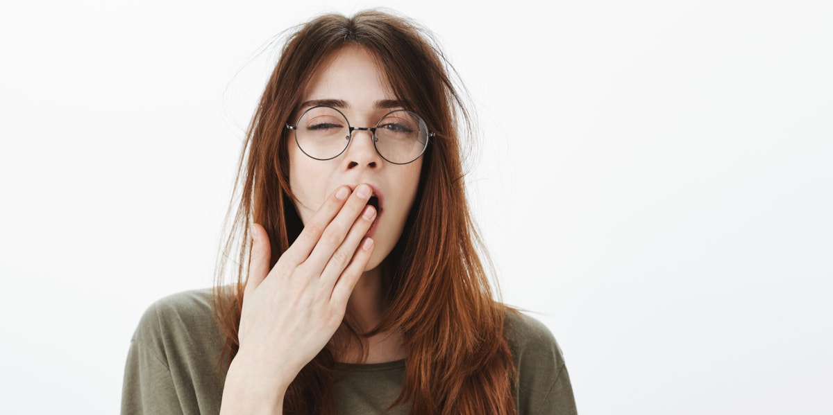 8 Signs You're Sleep Deprived That Have Nothing To Do With Being Tired woman yawning