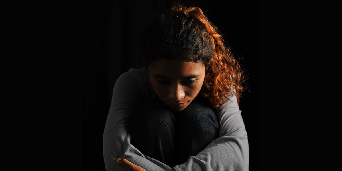 woman sitting alone in dark room