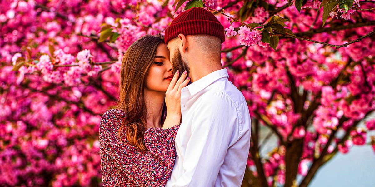 loving couple embracing under pink floral tree