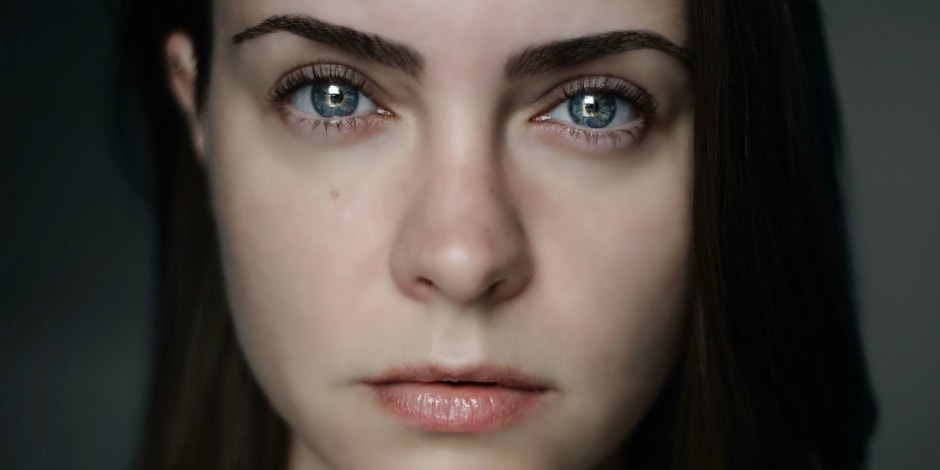 woman with dark hair staring directly at camera