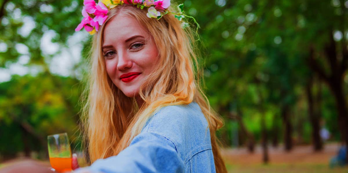 girl in flower crown holding man's hand