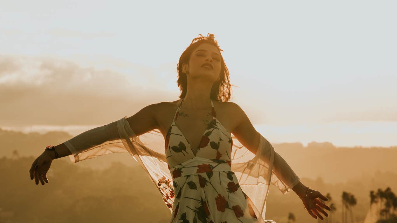 carefree woman enjoys sunshine in a field