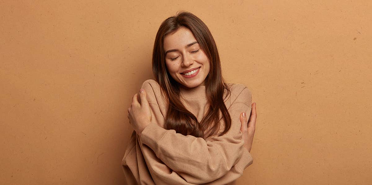 9 Ways Being In Love Completely Changes Your Personality woman hugging herself