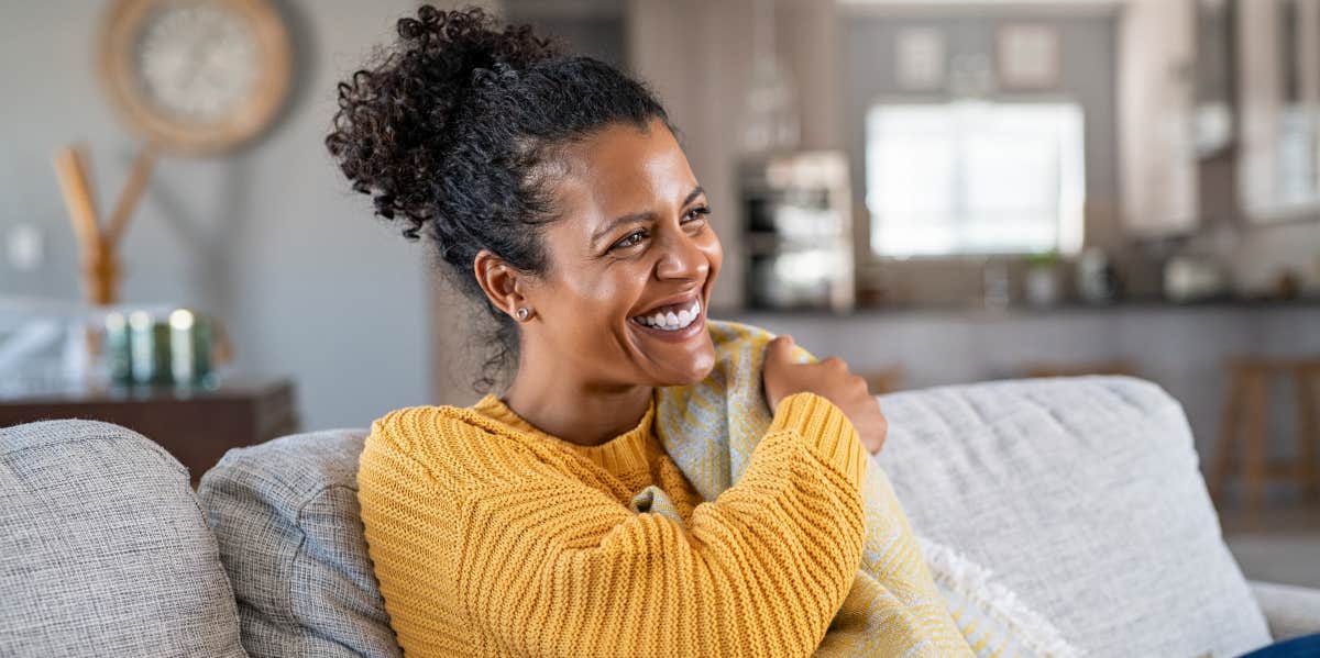 Boost Your Emotional Bandwidth A Black woman with hair in a ponytail smiles in a sunny room