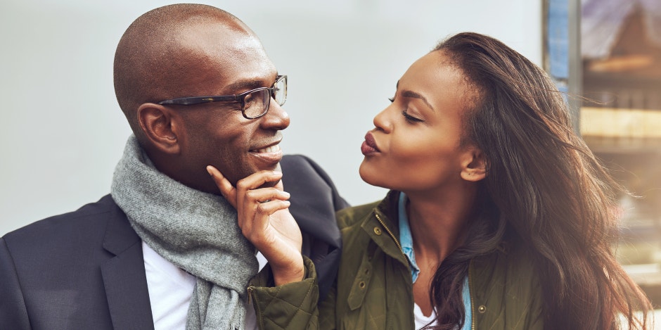 14 Easy Ways To Deepen Emotional Intimacy With Your Partner Woman holds a mans chin in her hands as she makes a kissing face