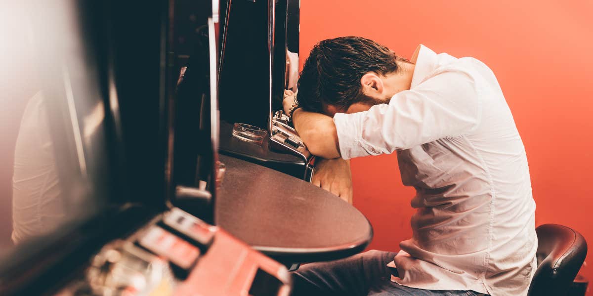 Man losing at slot machines in casino