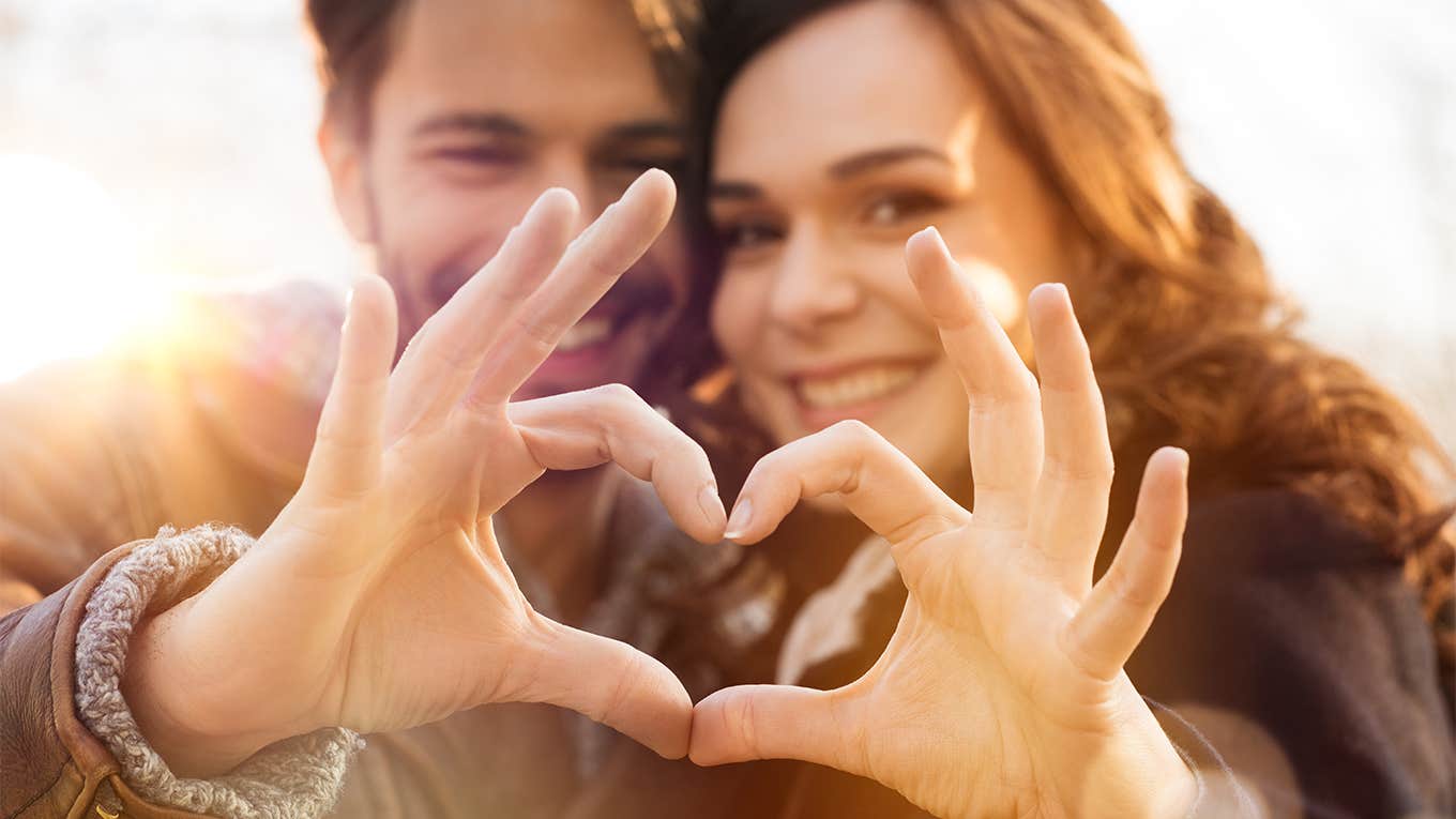 Closeup of couple making heart shape with hands