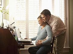 pregnant couple at computer