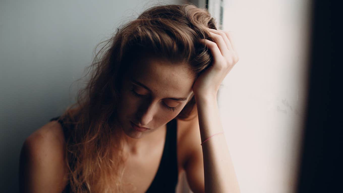 Portrait of young beautiful woman near misted window