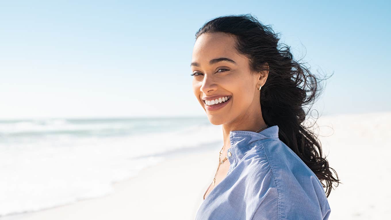 Portrait of young woman at sea looking at camera