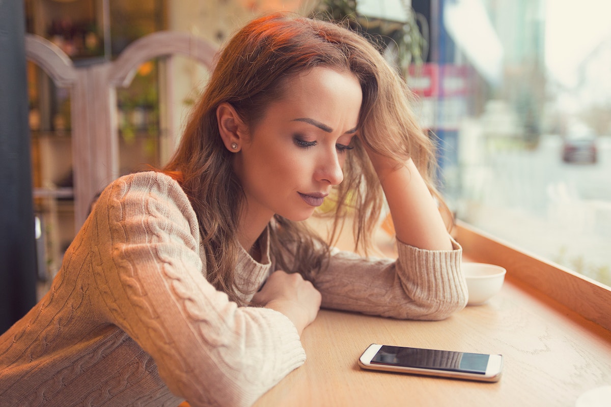 sad woman looking at her phone