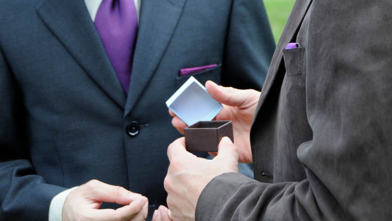 Groom and best man looking at wedding ring