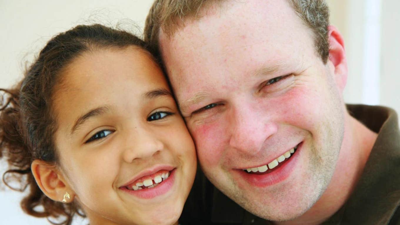 brunette daughter and red headed father posed cheek to cheek and smiling