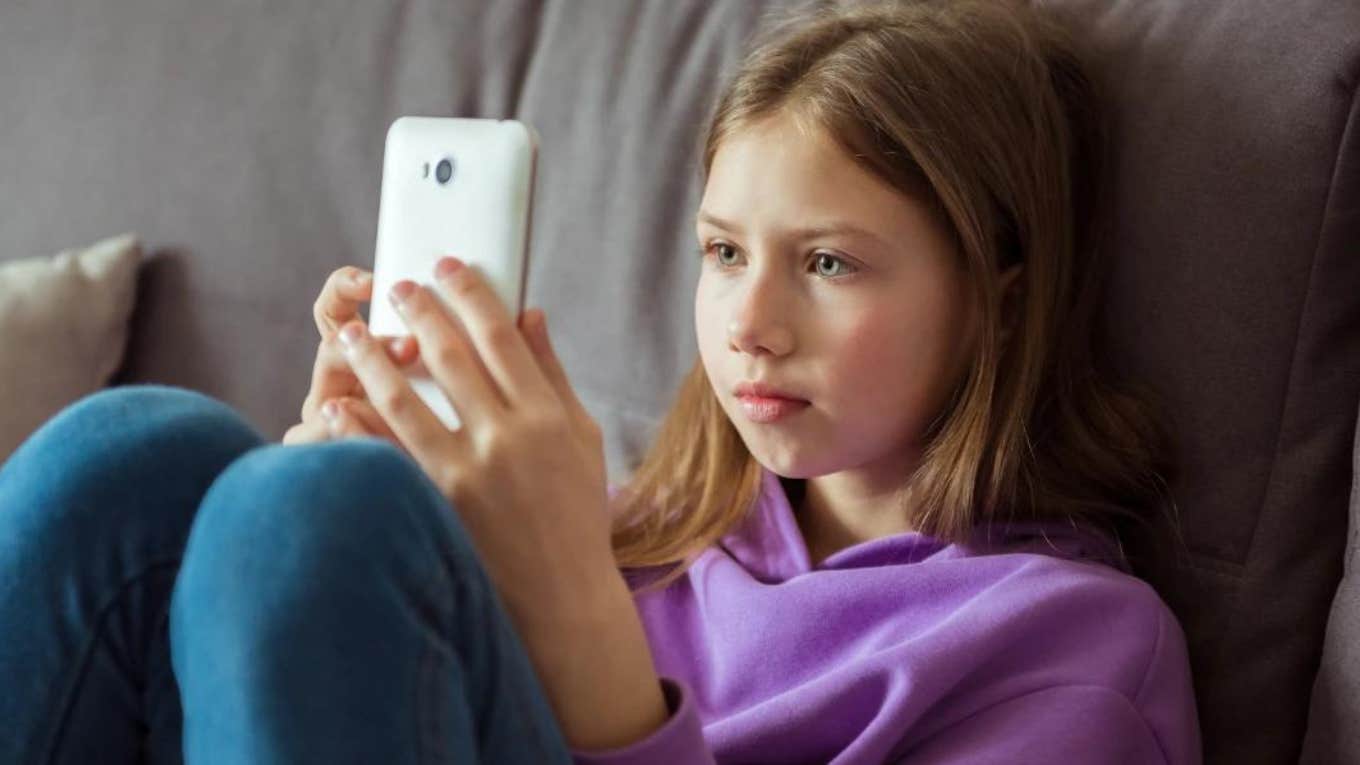teen girl in purple sweater holding phone
