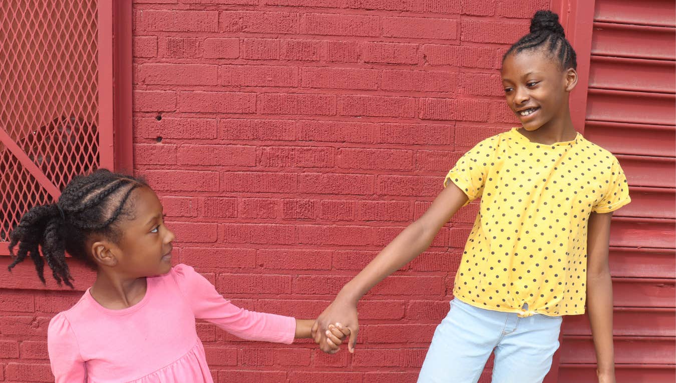 two young girls holding hands