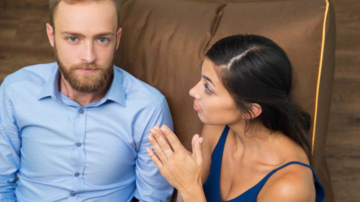 man in blue shirt having serious conversation with woman in tank top