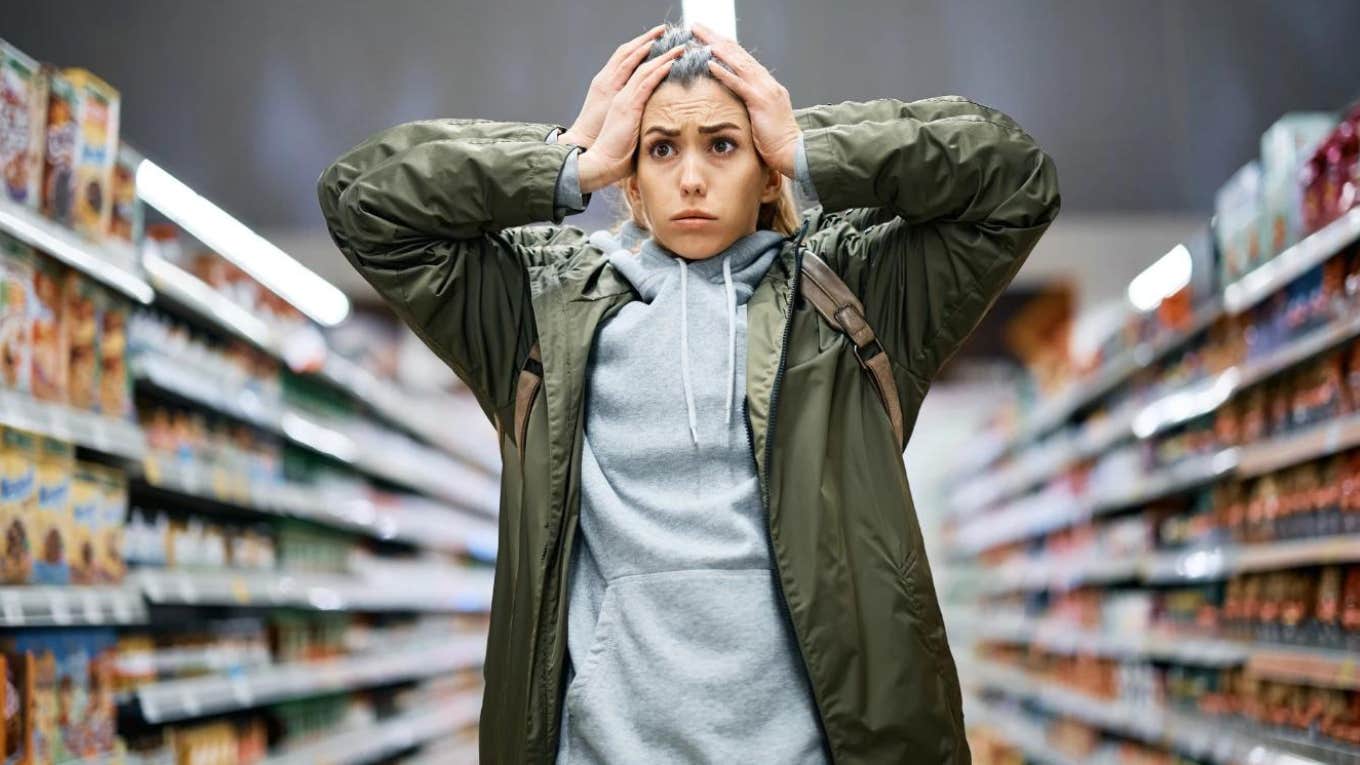 perplexed woman in grocery store with hands on head