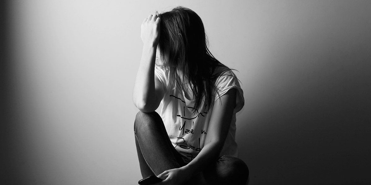 woman with hand on forehead in black and white