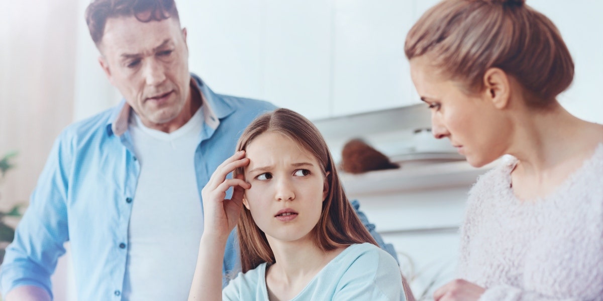 mother and father scolding daughter