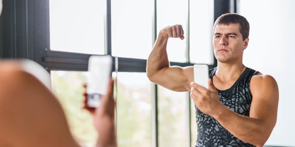 man with muscles looking in the mirror