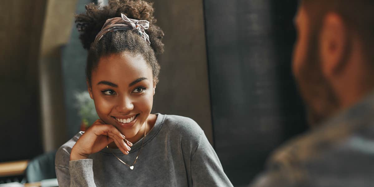 woman smiling at man from across the table 