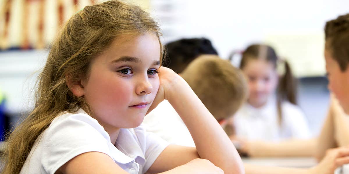 young girl sitting in classroom at school