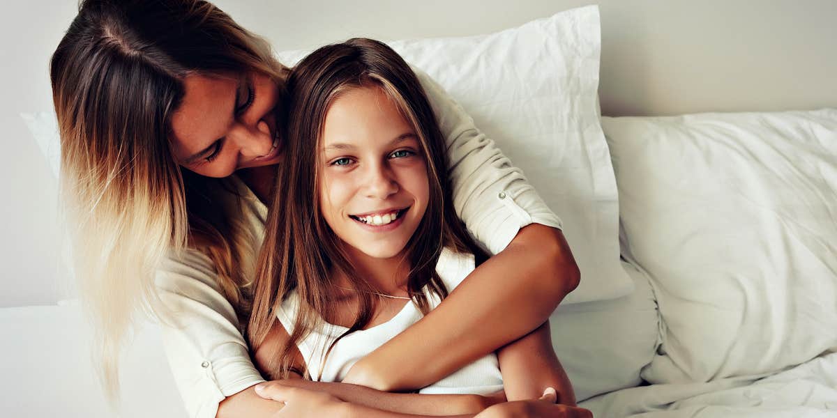 mother and tween daughter cuddling