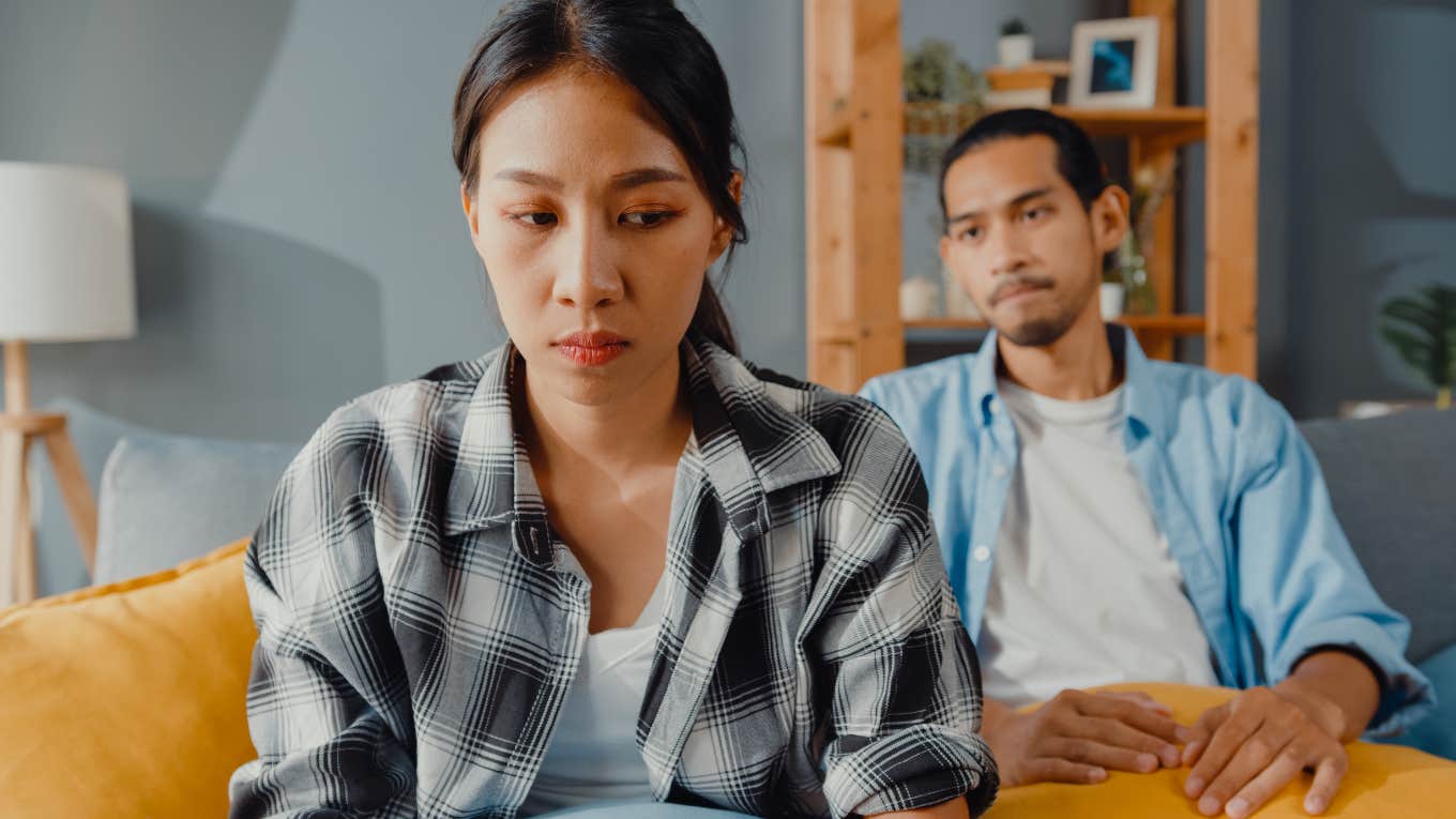 wife upset with husband while sitting on couch