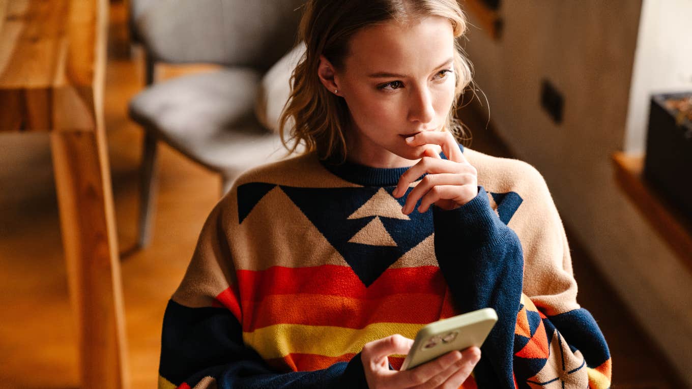 pensive woman holding phone