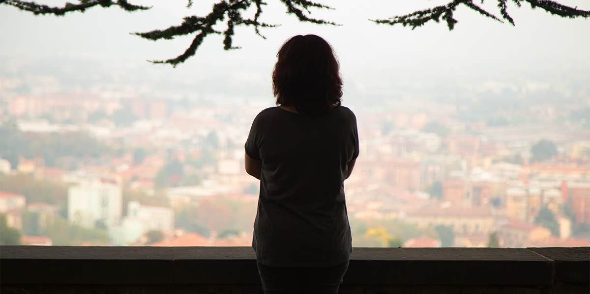 woman standing alone overlooking town