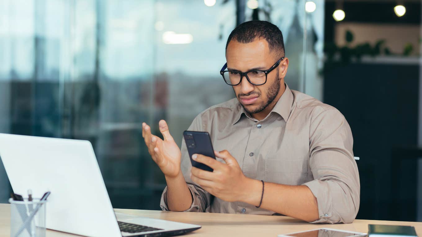 annoyed man reading an ai-generated rejection letter